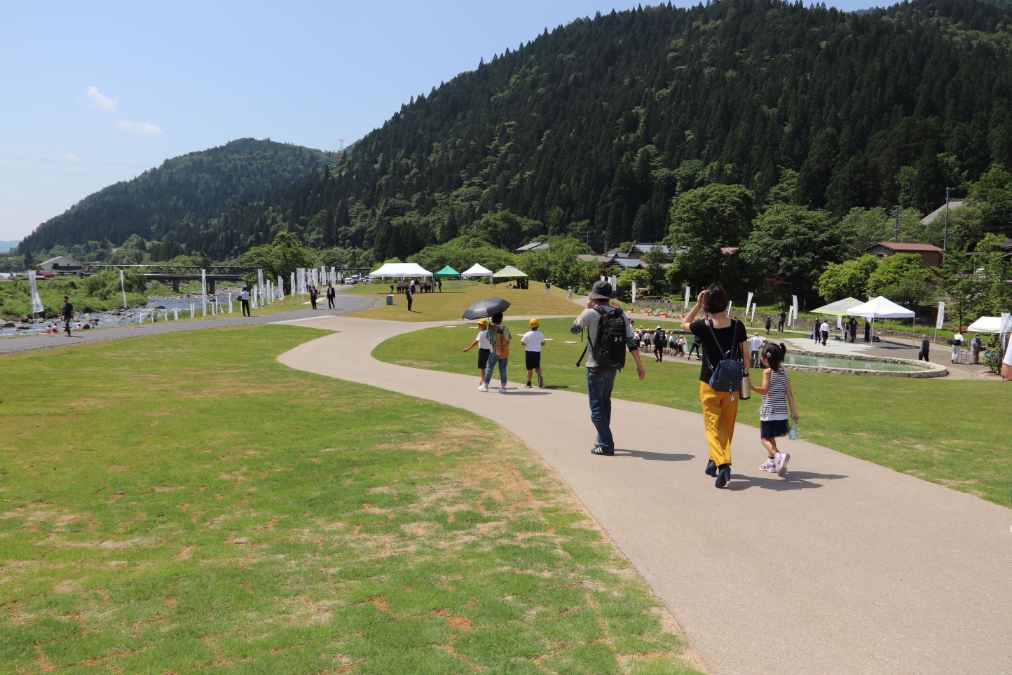 広々とした公園を散歩する親子連れ