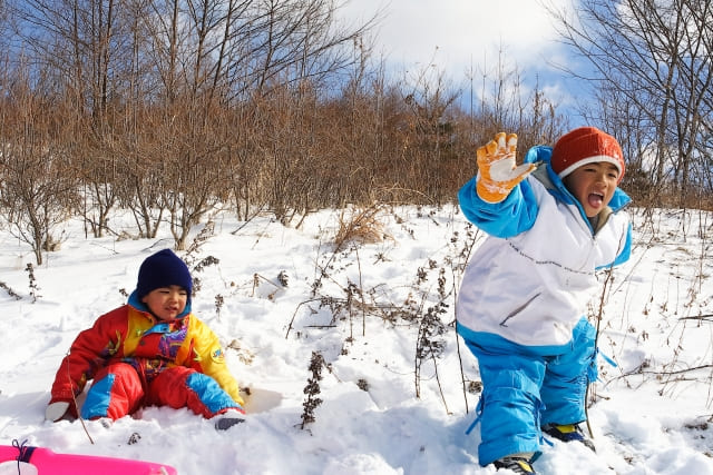 雪が積もった場所で遊ぶ二人の子供